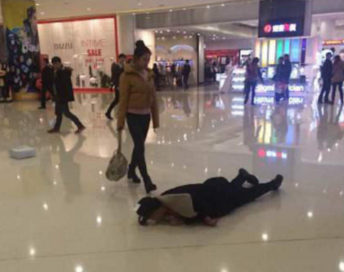 Chàng trai lăn lộn trên sàn nhà sau khi cãi nhau với bạn gái. Ảnh: Weibo.